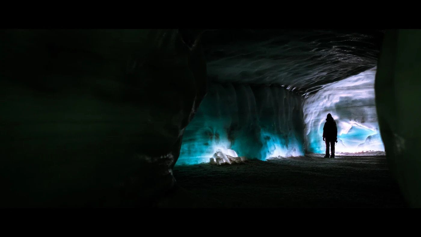 A visitor silhouetted in the lit Into the Glacier tunnel inside Langjökull, the stop on the Húsafell Langjökull snowmobile tour combo